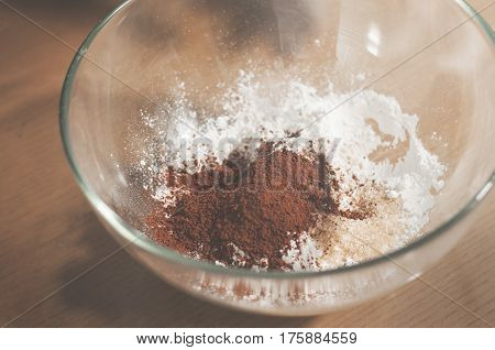Cocoa powder with bakers flour in glass bowl.