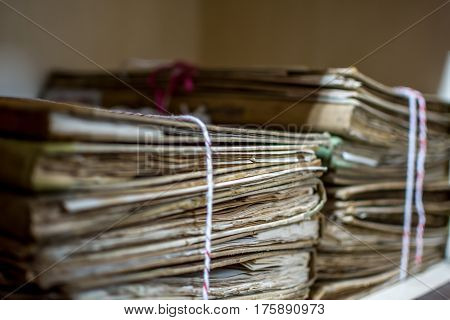 Paper files in a folder is a old documents or old letter it's a age-old and ancient archiving by stacking up in a documents paper shelf messy order