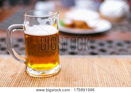 beer mug with beer on a table outside