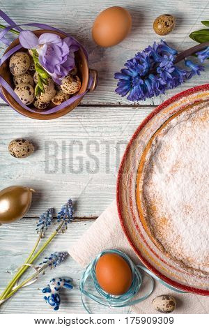 German Easter cake, eggs, flowers, ribbons on the table vertical