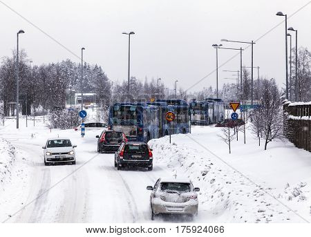 UMEA, SWEDEN ON MARCH 02. View of a modern street, road and the traffic in snowy condition on March 02, 2017 in Umea, Sweden. Signs, lampposts and buildings. Editorial use.
