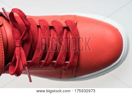 Fashion shoes with shoestring. Red sneaker and shoelace isolated on white background