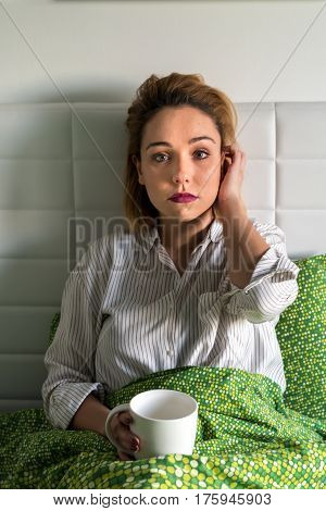 Girl in bed with cup. Need a rush of energy