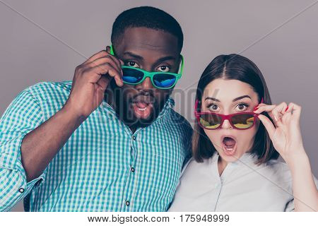 Portrait of shocked young multinational couple in love in glasses
