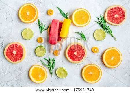 homemade ice-cream with sliced oranges and lime on stone table background top view pattern