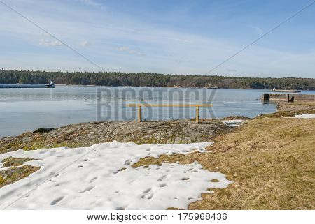 Yellow bench by lake in winter, Sweden