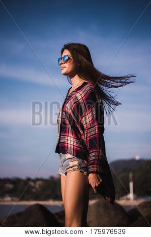 young stylish happy hipster woman traveling around the world wearing aviator sunglasses, denim shirt, tropical island lagoon vacation.