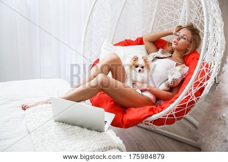 Beautiful girl sexy blonde in lingerie posing in the bathroom with the dog
