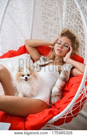 Beautiful girl sexy blonde in lingerie posing in the bathroom with the dog