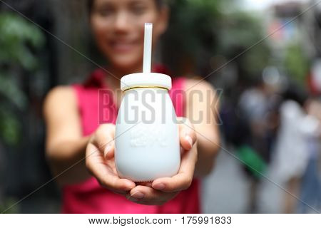 Traditional Beijing yogurt. Typical local street food of China, bottle of dairy drink. Travel lifestyle woman showing chinese dairy product.