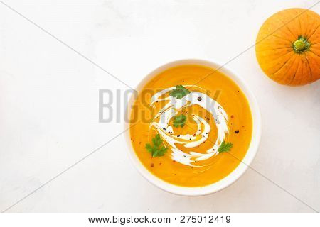 Pumpkin Soup With Cream And Pumpkin Seeds Isolated On White Background. Autumn Concept.