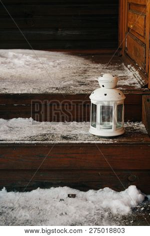 White Lantern On Theon The Snow-covered Porch. Wooden Staircase To The House. Beautiful Winter Backg
