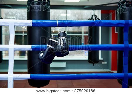 Boxing Gloves In A Boxing Ring With Bags In The Gym.