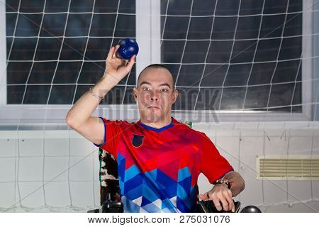 Boccia. A Disabled Sportsman Sitting In A Wheelchair Swinging A Little Blue Ball