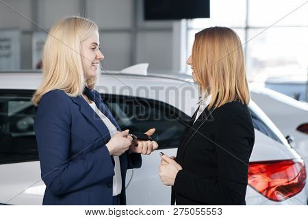 Woman Receiving Car Keys From A Dealer