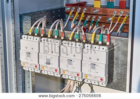 The Electrical Wires Or Cables Are Connected To The Circuit Breakers. In The Background, Copper Busb