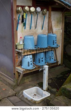 Nagasaki, Japan - October 24, 2018: Washing corner with modern plastic buckets and water pans at the historical Sofukuji Temple grounds 