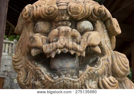 Nagasaki, Japan - October 22, 2018: Traditional old stone lion guardian at the Sofukuji Temple grounds close up 
