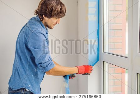 Man In A Blue Shirt Does Window Installation