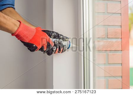 Man In A Blue Shirt Does Window Installation