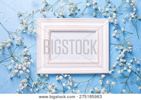 Empty Frame And  Fresh White Gypsofila  Flowers On Blue Textured Background. Top View. Flat Lay. Pla