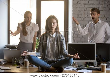 Calm Serene Employee Meditating In Office Ignoring Annoying Coll