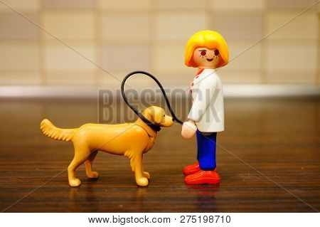 Poznan, Poland - December 22, 2018: Playmobil Toy Woman Walking Her Dog Out With A Line In Soft Focu