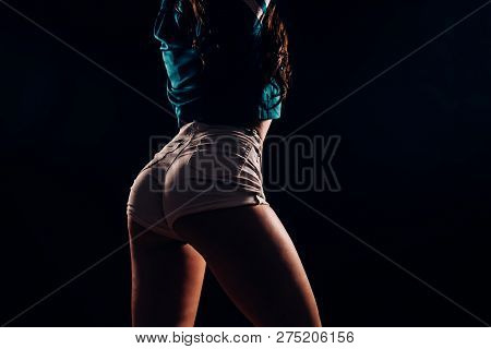 Closeup Silhouette Of A Beautiful Female Figure On A Black Background In The Dark. Fitness And Dance