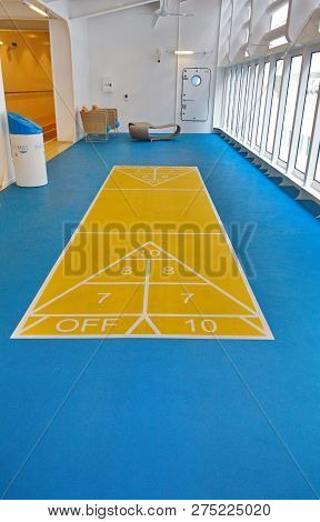 A Yellow And Blue Shuffleboard Court On The Deck Of A Luxury Cruise Ship