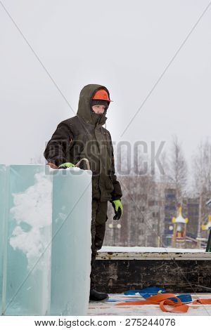 Portrait Of A Fitter Slinger In A Jacket And Helmet On The Unloading Of Ice Plates
