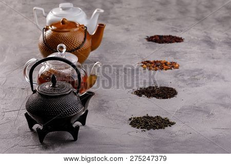 Still Life For A Tea Card. Different Varieties Of Tea Leaves And A Variety Of Forms Of Teapots. The