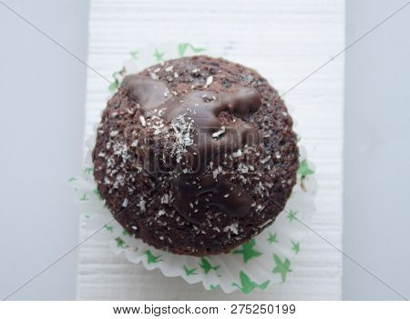 Chocolate Cupcake Wiht Coconut Shavings On A Light Backround