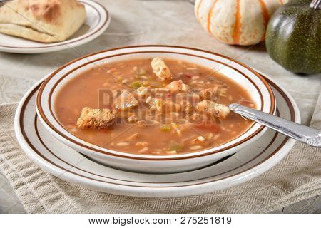 Bowl Of Gourmet Homemade Chicken Gumbs Soup With Rice And A Dinner Roll