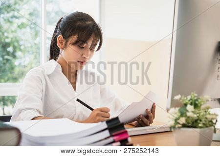 Asian Business Woman Offices Check Working For Stack Of Unfinishedd Documents Papers On Computer In 