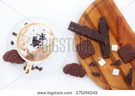 Cup Of Esspreso Or Late Macciato With Whipped Cream, Cinnamon Sticks, Cookies And Chocolate On Snow.