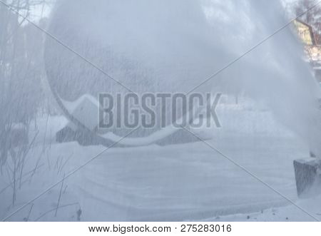 A White Snowstorm From Electric Snow Thrower In A Winter Garden