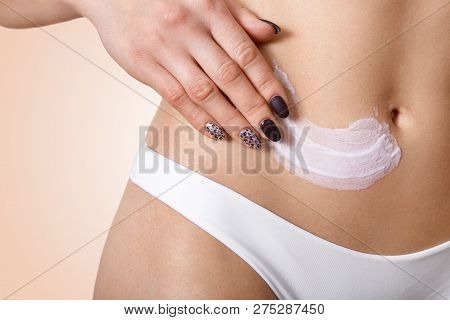 Close Up Shot Of Slim Woman Applies Cream On Body, Wears White Panties, Cares Of Skin, Prepares For 