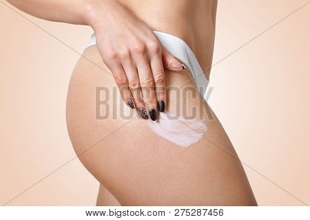 Sideways Shot Of Slim Woman Applies Body Cream On Hip, Wants To Have Flawless Ideal Skin, Has Black 