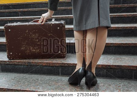 Girl On The Steps Stretches To The Old Suitcase Hand