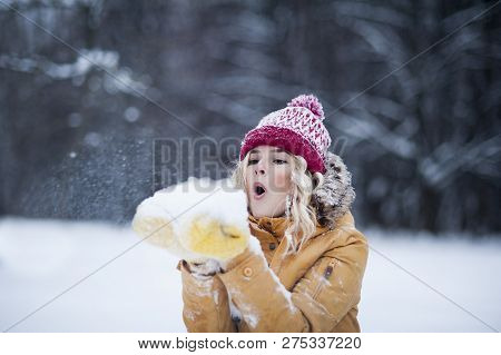 Very Beautiful Bright Young Girl In A Red Hat And Yellow Mittens On The Background Of A Winter Park