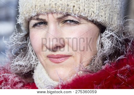 Hoarfrost On Hair And Eyelashes. A Girl In A Red Jacket And A White Knitted Hat In The Winter In The