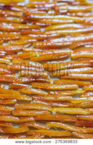 Candied Orange Peel, Cooked In Sugar Syrup With Vanilla And Ginger, Drying On Parchment.