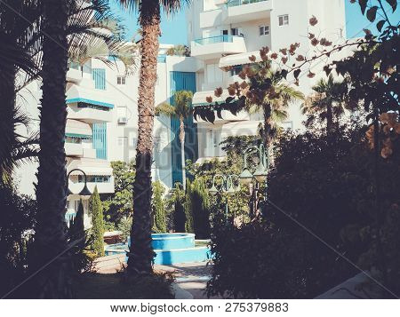 Residential Buildings And Fountain Surrounded With Green Plants In  Rishon Le Zion.