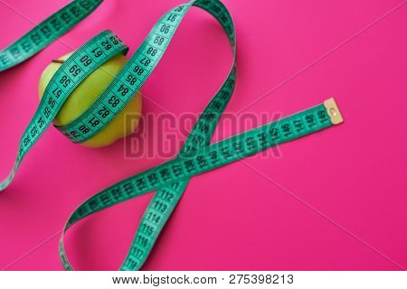 Green Apple Measured The Meter On A Pink Background