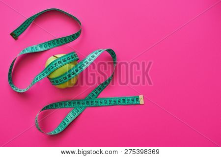 Green Apple Measured The Meter On A Pink Background