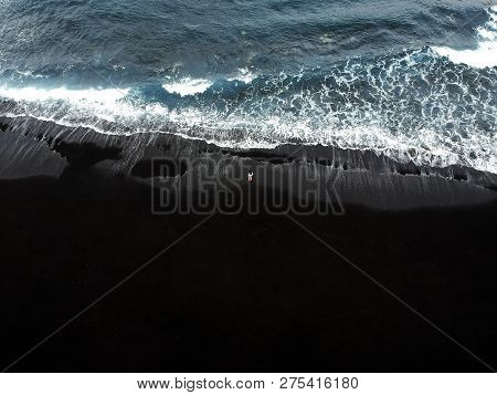 Woman Standing On A Black Sand Beach Of Los Gigantes In Tenerife, Canary Islands, Spain