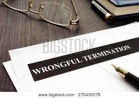 Documents About Wrongful Termination On A Wooden Desk.