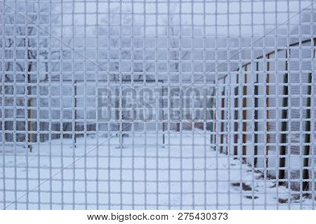 Snowed Sport Yard Behind Frosty Metal Grid Net In Winter