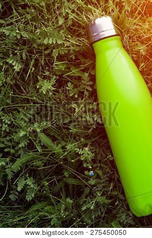 Stainless Thermos Water Bottle, Matte Light Green Color. Mockup Isolated On Green Grass Background W