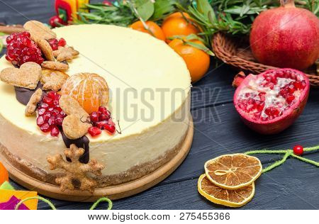 Homemade Heesecake On Black Wooden Bacground Decorated By Orange, Cookies, Pomegranate, Rosemary. Mo
